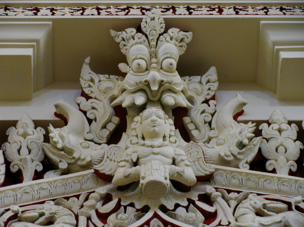 Ein Gebäude mit einer Skulptur an der Spitze mit floralen Designs.