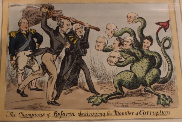 Eine Karikatur auf einem Blatt Papier, das Figuren mit der Bezeichnung "Reformchampions" zeigt, die eine Figur mit der Bezeichnung "Korruptionsmonster" angreifen, mit dem Text "Die Reformchampions zerstören das Korruptionsmonster."