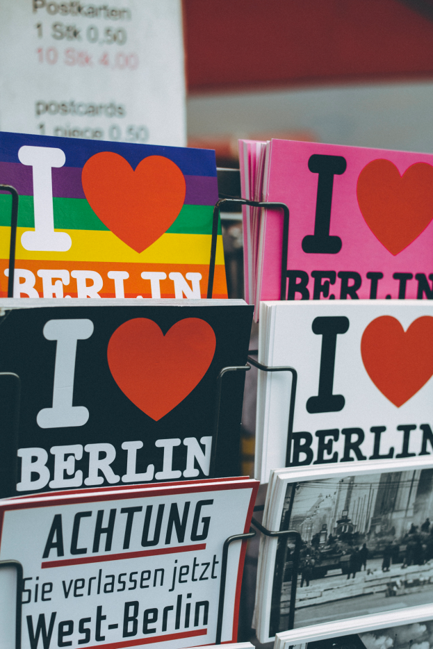 Ein Gestell mit verschiedenen Büchern und Postern mit der Aufschrift 'Ich liebe Berlin' vor einem sanft unscharfen Hintergrund.