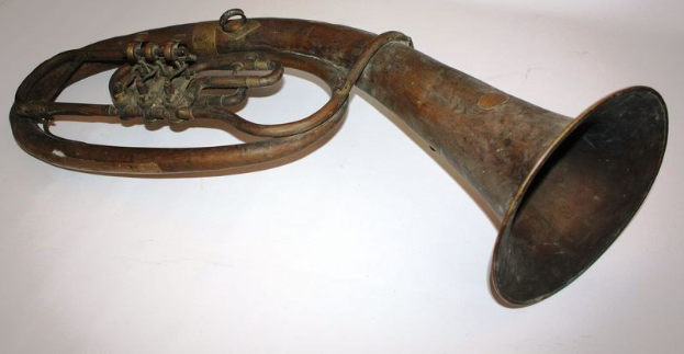 Alter Messinghorn mit glänzendem Finish, gebogenem Hals und aufgeblasenem Trichter, verziert mit detaillierten Gravuren, auf einem weißen Hintergrund.