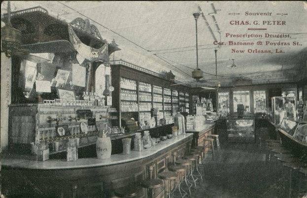 Schwarzes und weißes Foto eines alten Apothekeninneren in New Orleans, Louisiana, mit Hockern, Tischen mit Flaschen und Gegenständen, Glasfenstern auf der rechten Seite und Text oben.