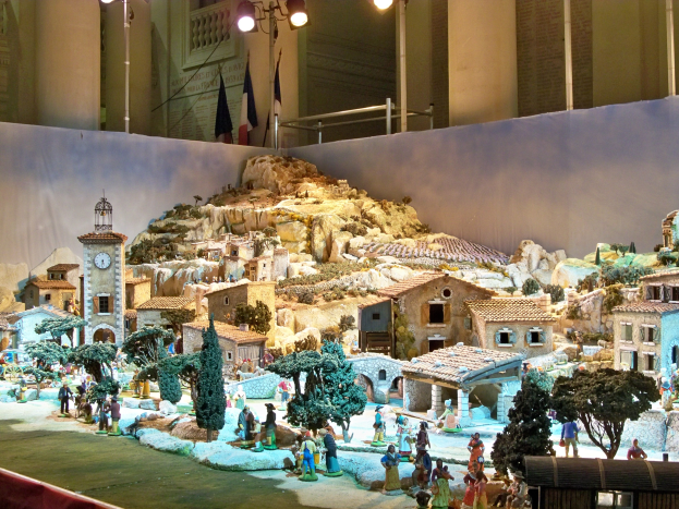 Ein detailliertes Modell einer Krippe, das im Museum ausgestellt wird und Miniaturfiguren, Strukturen und beleuchtete Elemente enthält.