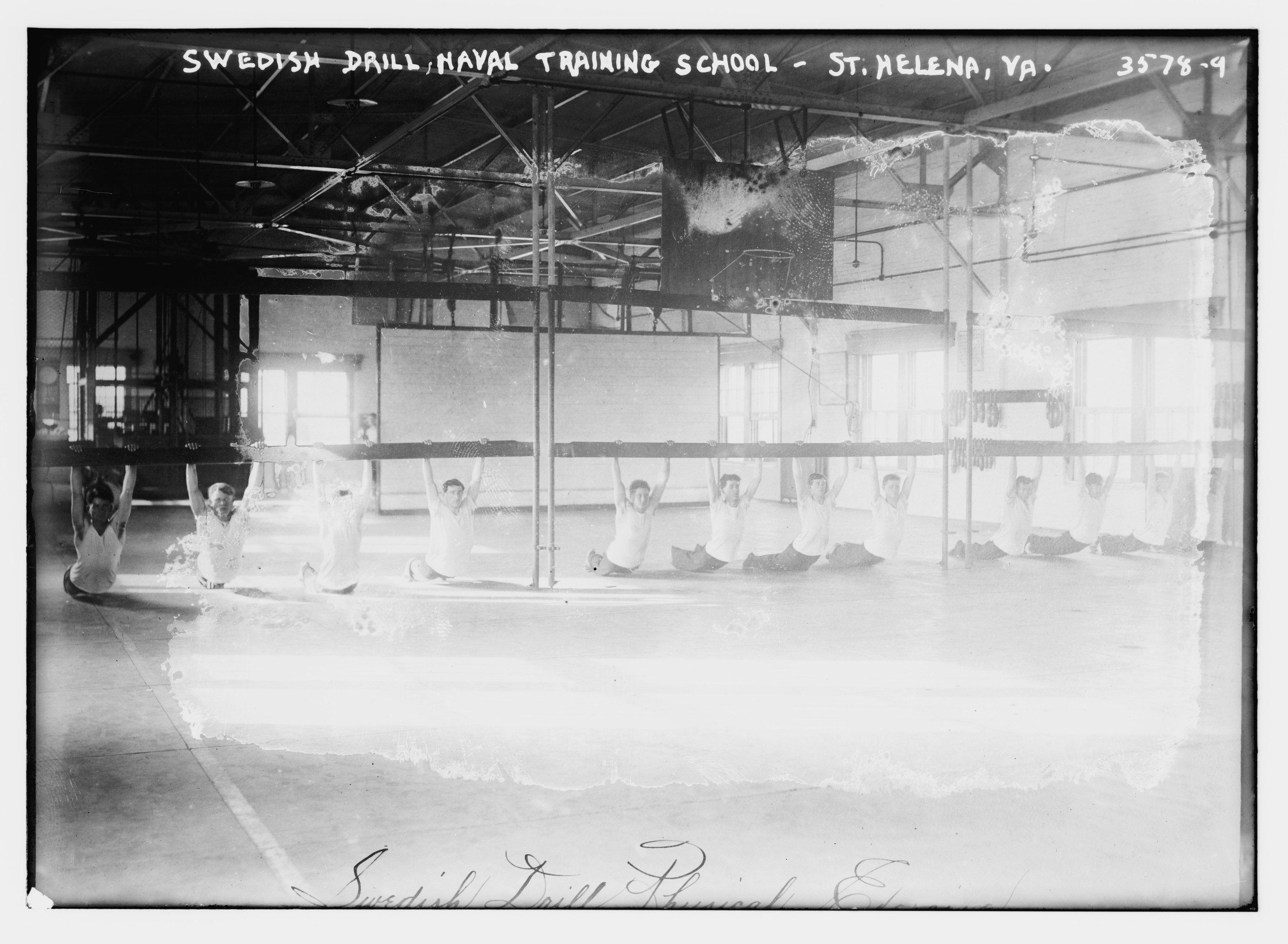 Schwarzes und weißes Foto einer Gruppe, die Gymnastik in einem Gym mit Stangen, Stäben, Fenstern und einer Wand im Hintergrund macht, mit Text oben und unten.