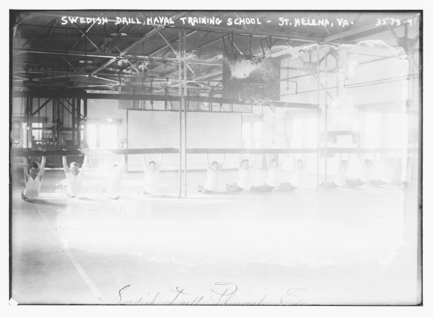 Schwarzes und weißes Foto einer Gruppe, die Gymnastik in einem Gym mit Stangen, Stäben, Fenstern und einer Wand im Hintergrund macht, mit Text oben und unten.