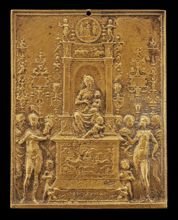 Goldene Plakette mit detaillierter Skulptur einer Frau in einem langen Kleid und eines Mannes in Anzug und Krawatte auf schwarzem Hintergrund, in Gold eingefasst.