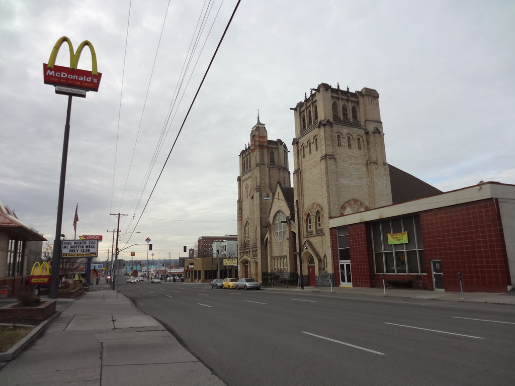Eine Straßenansicht mit Gebäuden rechts, Masten und Autos in der Mitte und einer McDonald's-Mast links.