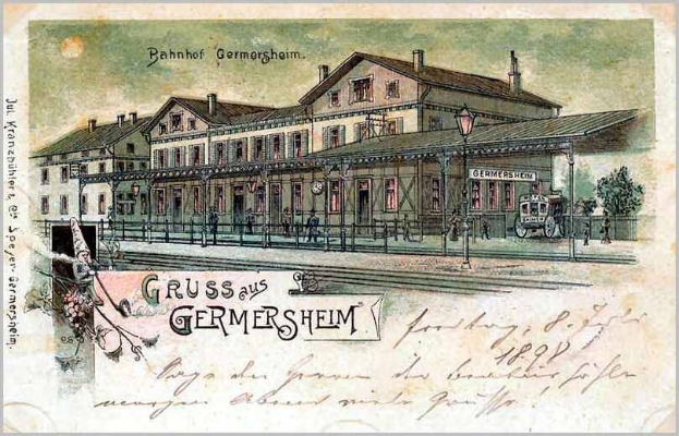 Schwarz-weiß-Postkarte des Bahnhofs Germersheim in Deutschland, die ein Bahnhofsgebäude, Menschen, Fahrzeuge, Bäume, einen Zaun, einen Straßenmast und einen bewölkten Himmel zeigt.