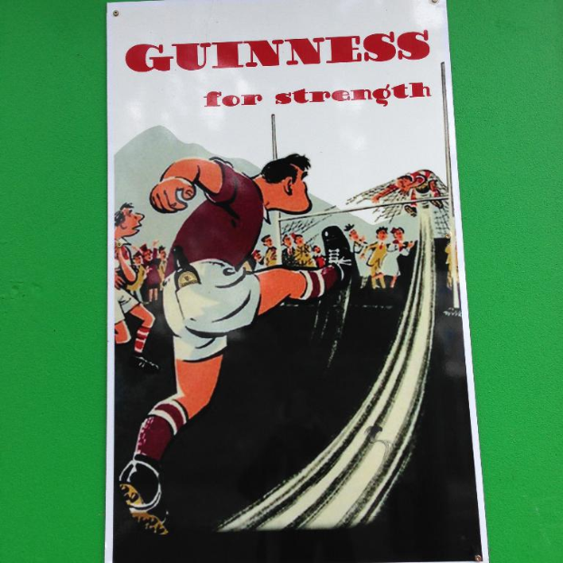 Ein Cartoon-Poster mit Menschen auf dem Boden und einer Person an einem Netz, mit der Aufschrift "Guinness für Stärke".
