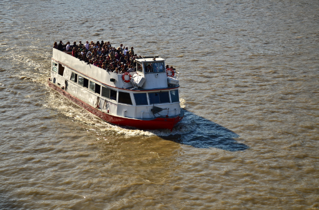 Ein Schiff segelt auf dem Wasser mit vielen Menschen auf seinem Deck.