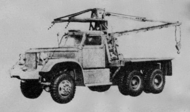 Schwarzes und weißes Foto eines großen Vierrad-Antriebs-Lkw mit einem Kran auf dem Rücken und einem flachen Anhänger, der angeblich das erste Schwerlastfahrzeug der Welt ist.