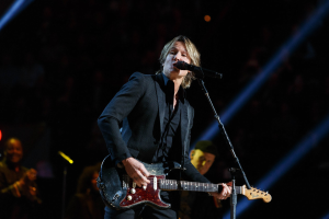 Keith Urban performs auf der Bühne im Joint im Hard Rock Hotel & Casino in Las Vegas, spielt Gitarre mit einem Mikrofon und Bandmitgliedern im Hintergrund in einer schwach beleuchteten Umgebung.