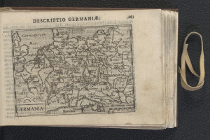 Ein offenes Buch mit einer Deutschlandkarte und angrenzendem Text, das auf einer schwarzen Oberfläche liegt.