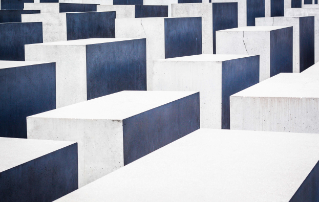 Eine große Anzahl von rechteckigen Betonplatten höherer Größe, die in einem Rastermuster auf einem geneigten Feld angeordnet sind, mit einem blauen Himmel im Hintergrund.