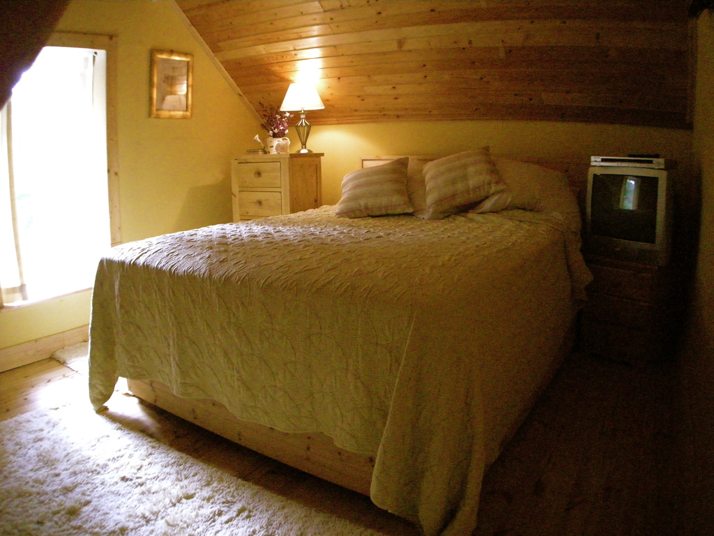Ein Schlafzimmer mit einem Bett, einem Nachttisch und einer Kommode.