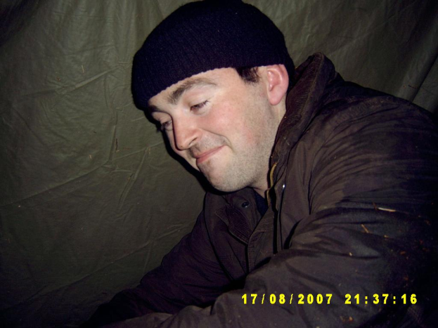 Eine Person in Jacke und Skalp steht neben einem Blatt.