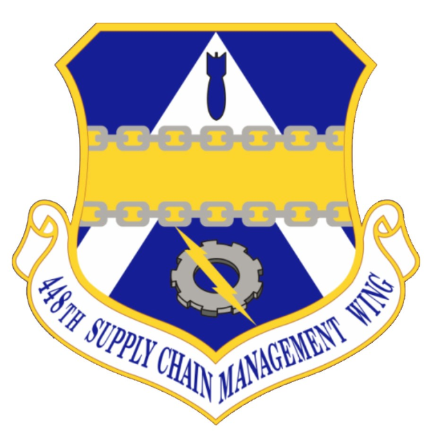 Logo der 48. Supply Chain Management Wing mit einem blauen Schild mit einem weißen Stern und einem weißen Banner mit der Aufschrift "Supply Chain Management" in blau, alles von einem weißen Rand und schwarzem Text umgeben.