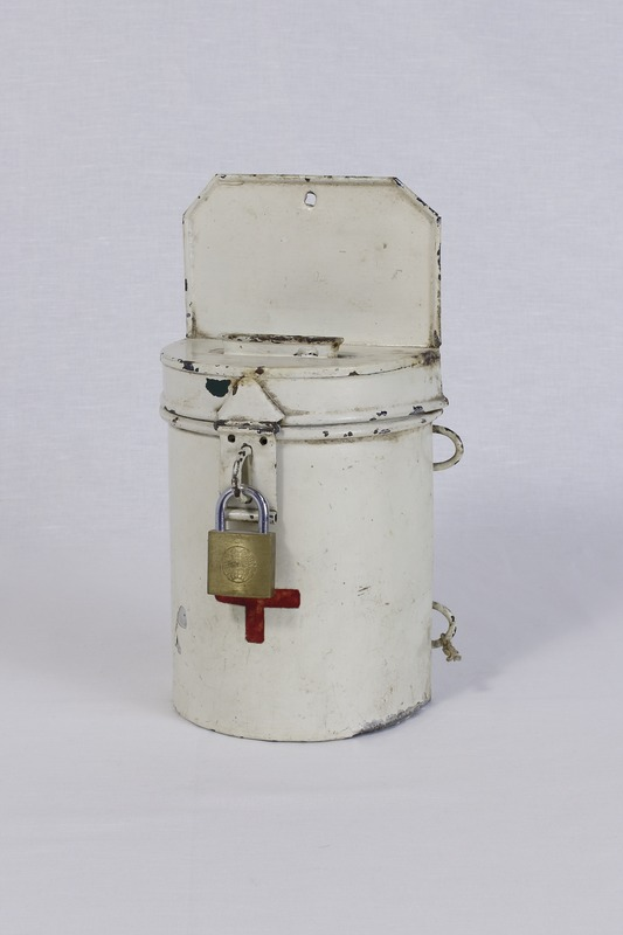 Ein weißer Metallkasten mit einem sicher befestigten Schloss darauf, der auf einer weißen Oberfläche steht.