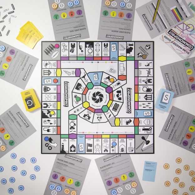 Ein Monopoly-Brettspiel auf einem Tisch mit Spielsteinen, Karten, Papieren und einem Bleistift verstreut.