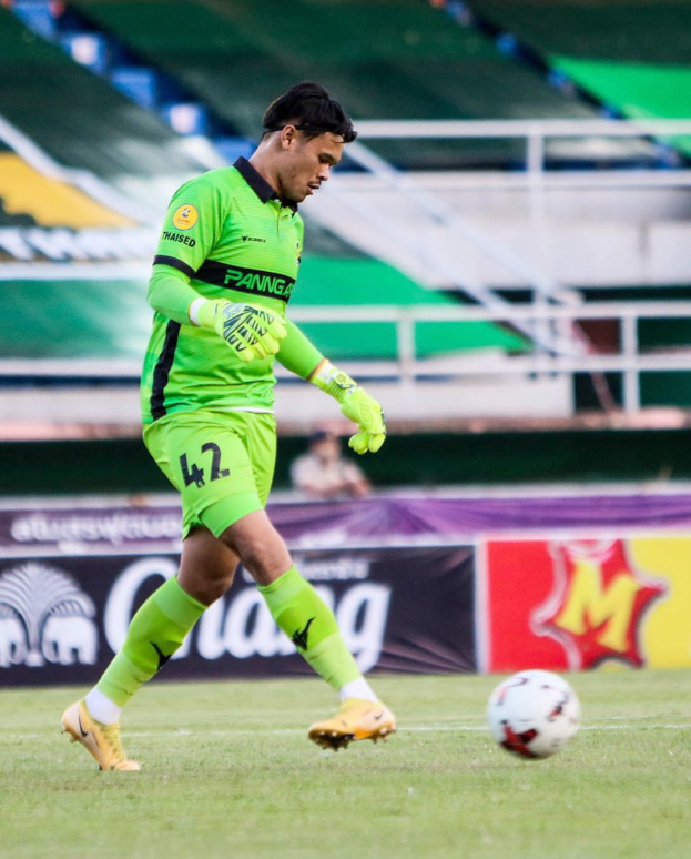Ein Torwart in einem grünen Trikot schießt einen Fußball auf einem Rasenfeld in einem Stadion mit Bannern, auf denen "Chivas USA vs Mexico City, 3-1, Copa Libertadores" steht.