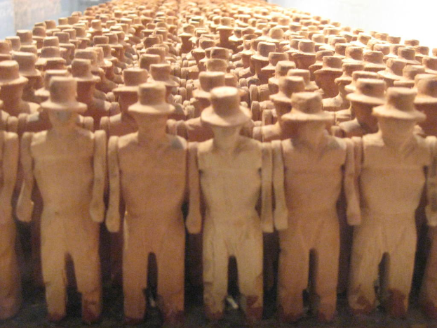 Mehrere Statuen einer Person, die steht und eine Mütze trägt.