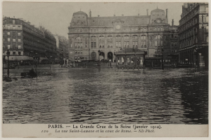 Schwarz-weiß-Foto einer überfluteten Straße in Paris mit Gebäuden, Straßenlaternen, Lichtern, Fahrzeugen und einem Himmel im Hintergrund, mit Text unten.