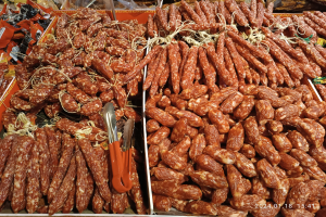 Ein Marktregal voller verschiedener Wurstwaren, verpackter Lebensmittel und anderer Gegenstände mit einem Wasserzeichen.