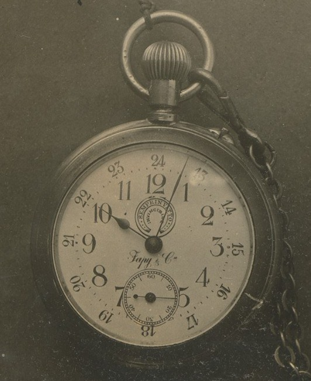 Altes Schwarz-Weiß-Foto einer Taschenuhr mit einer Kette, das eine nummerierte Uhr zeigt.